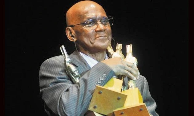 Cuco Valoy holding an award on stage