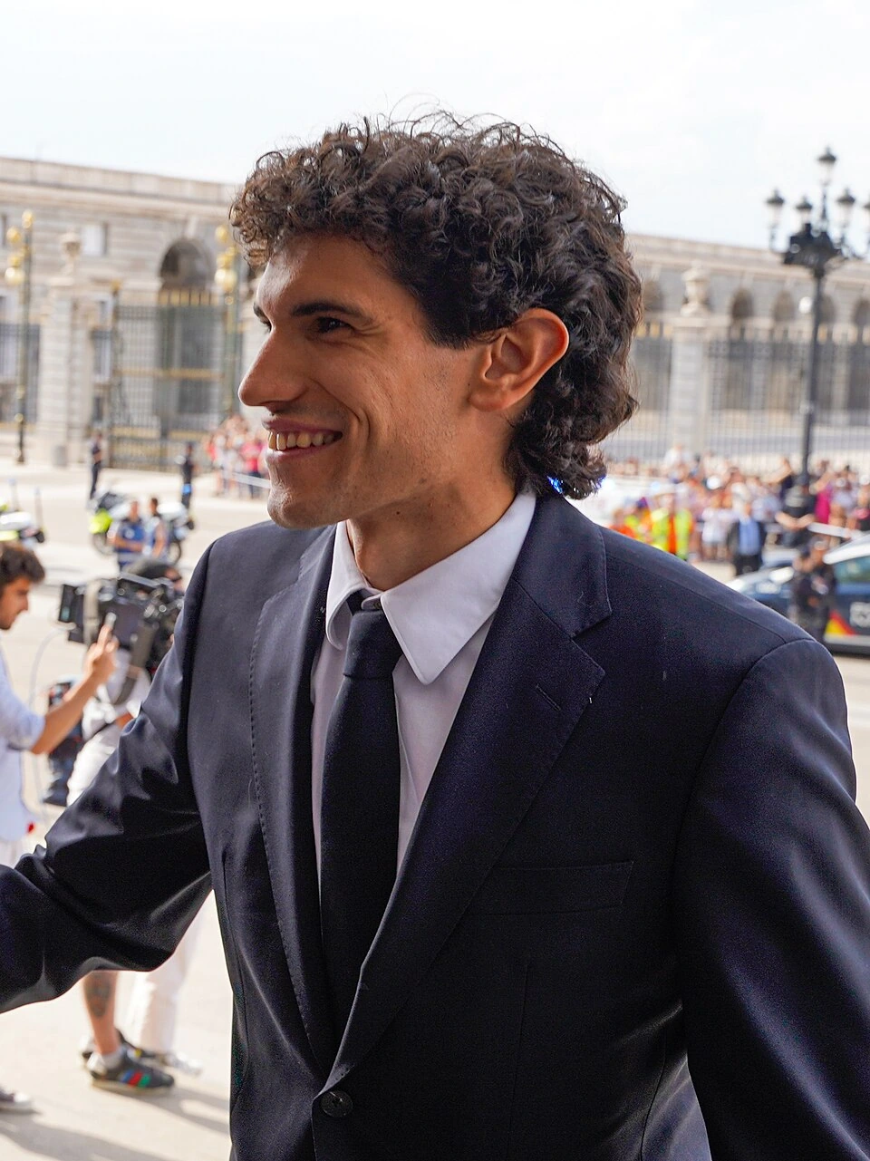 Jesús Vallejo in a suit smiling outdoors at a public event