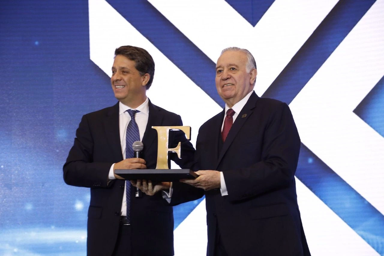 Valentín Díez Morodo at an awards event, holding a trophy on stage